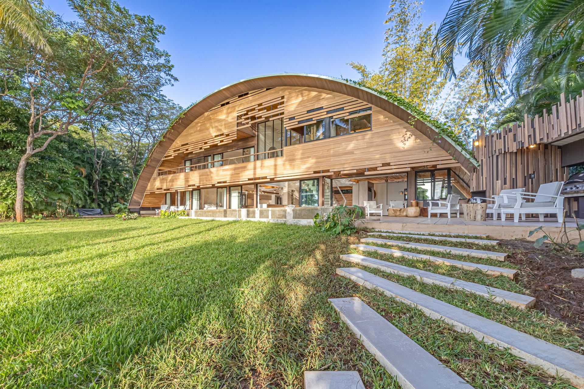 Villa Hermes vista desde el jardín — techo curvo de madera
